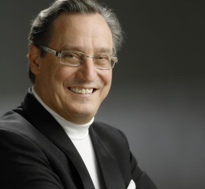 Hymyilevä mies kädet puuskassa.