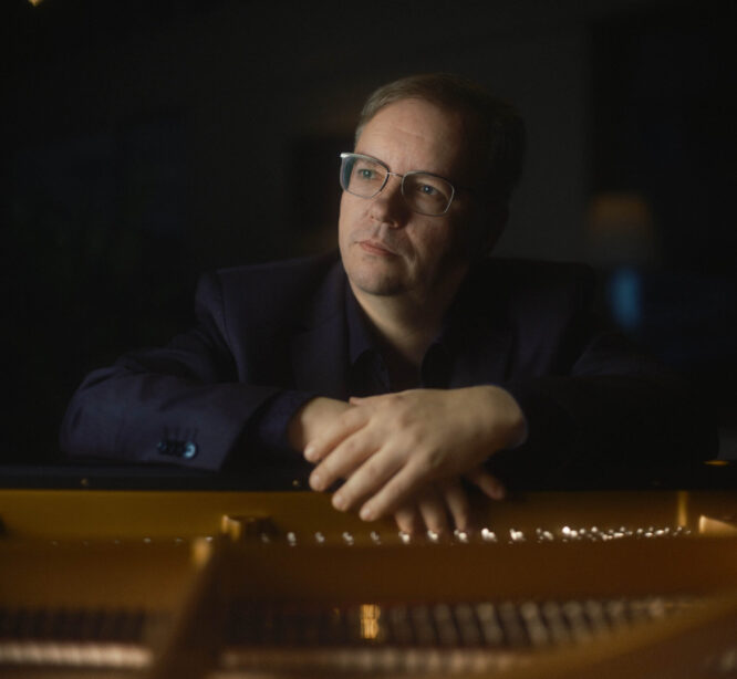 Mies kädet flyygelin kannella.