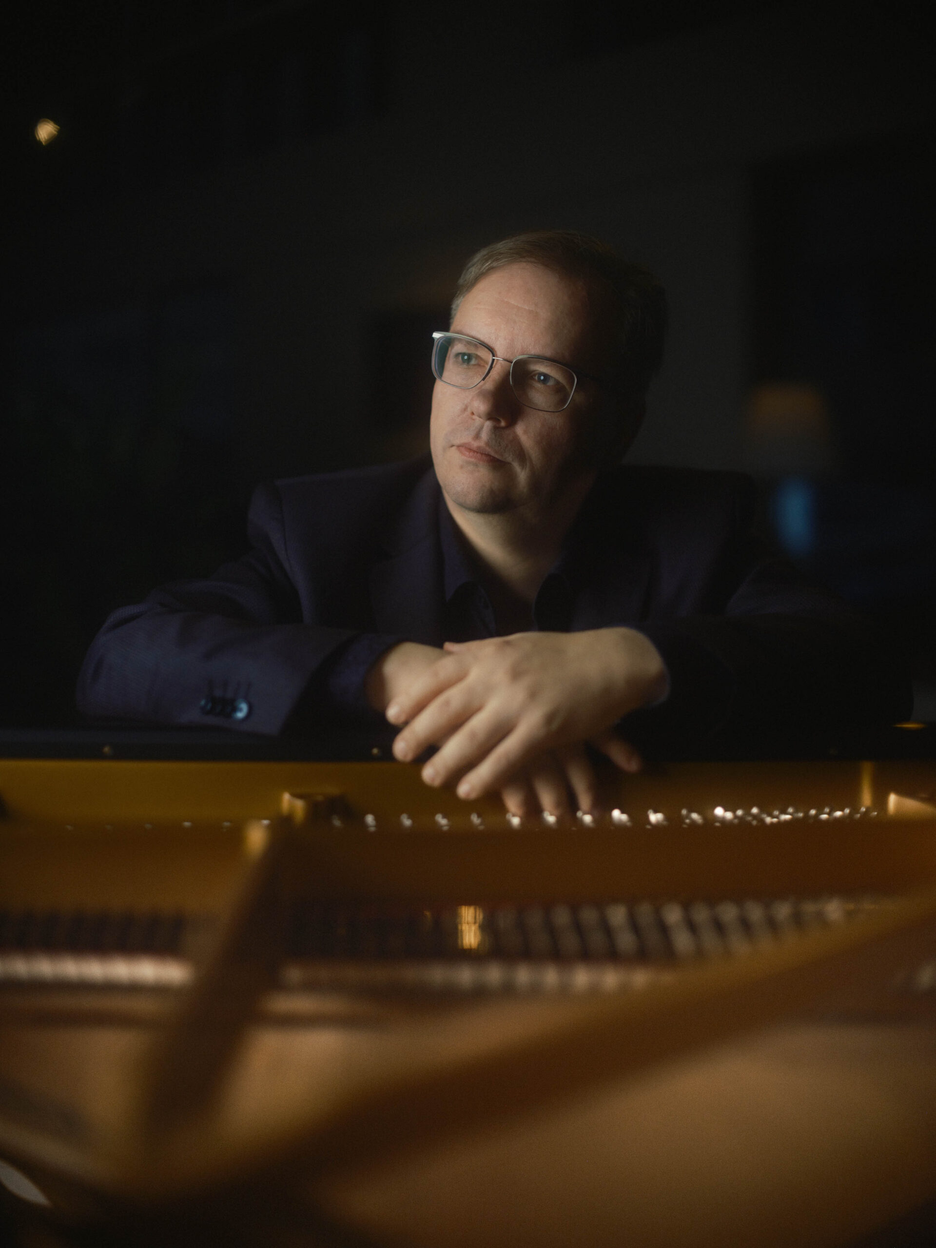 Mies kädet flyygelin kannella.