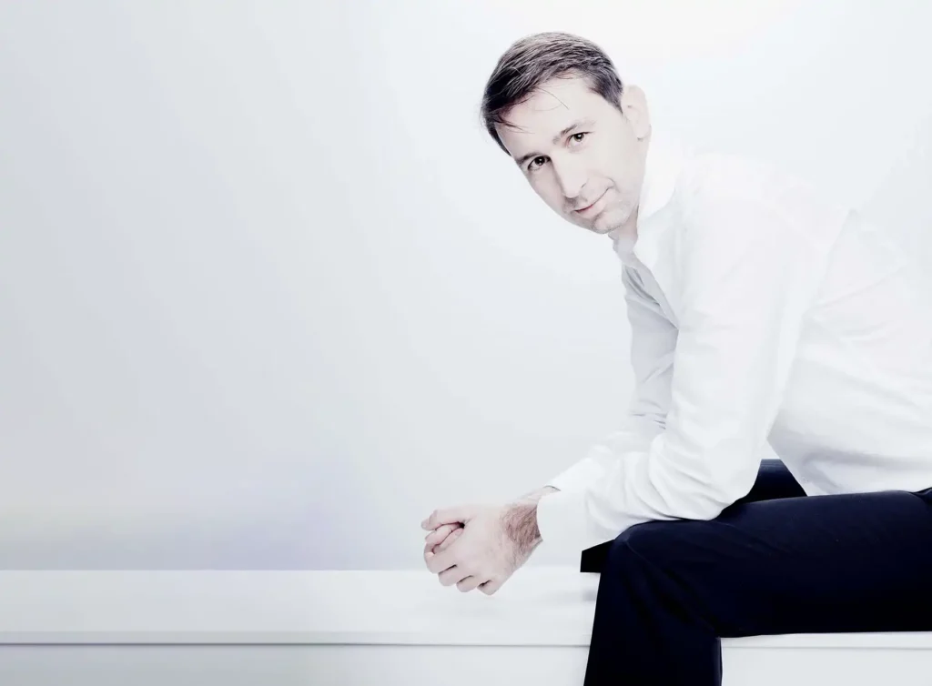 Mies istuu kädet polviin nojaten.