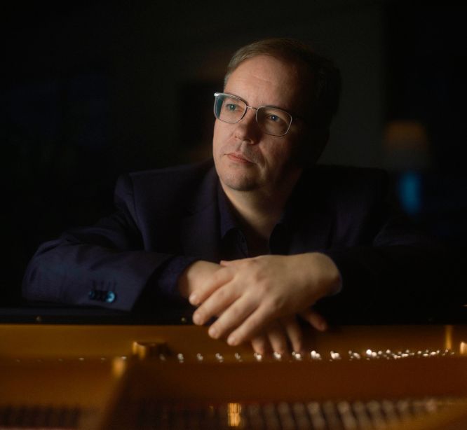 Mies kädet flyygelin kannella.