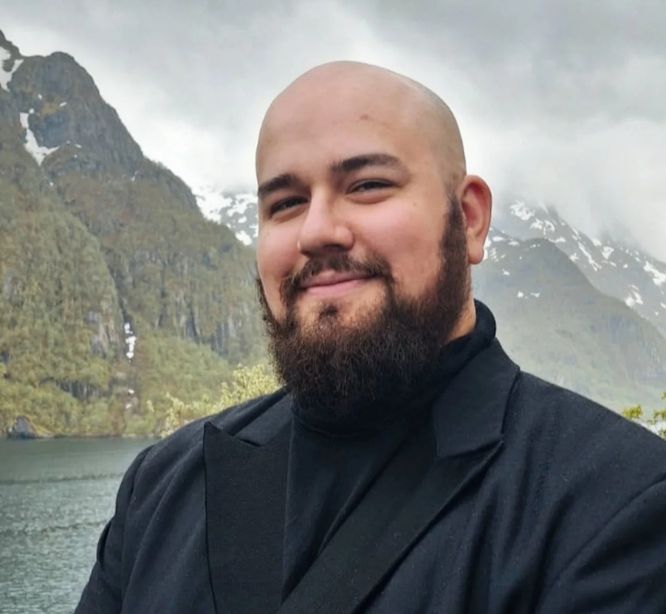 Hymyilevä mies, taustalla vuoristomaisema.